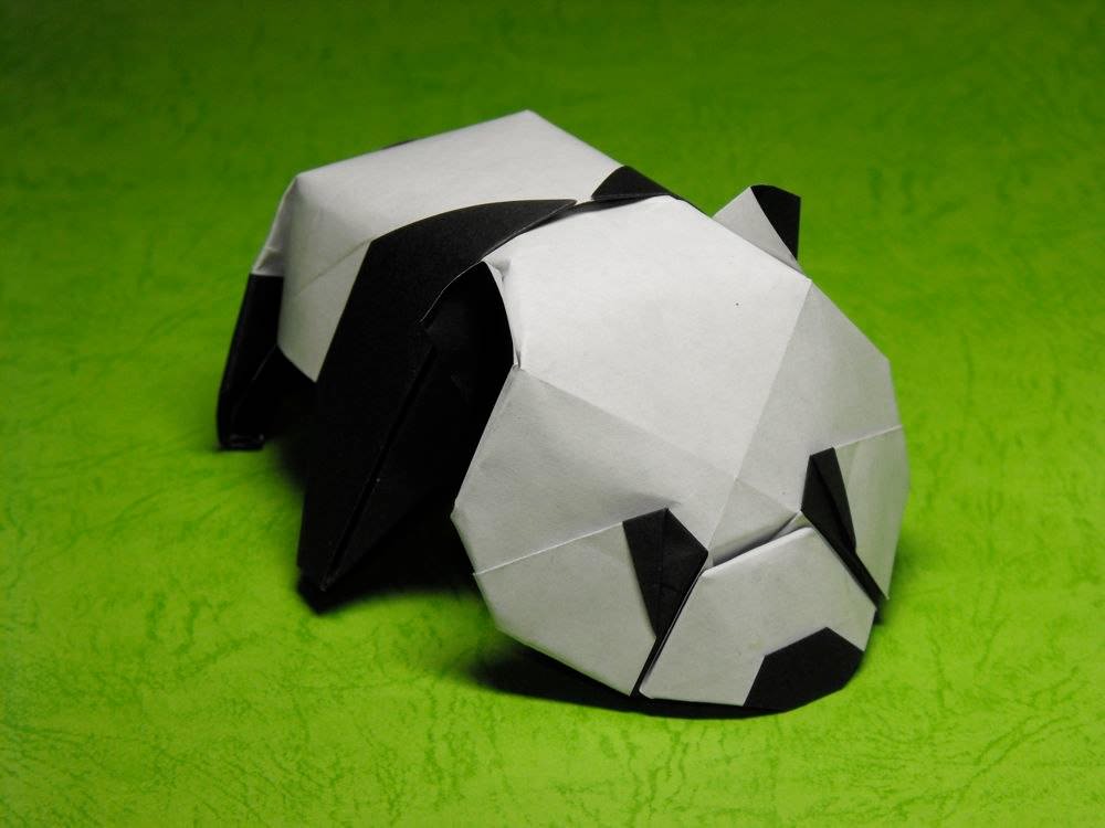 Origami panda on green background