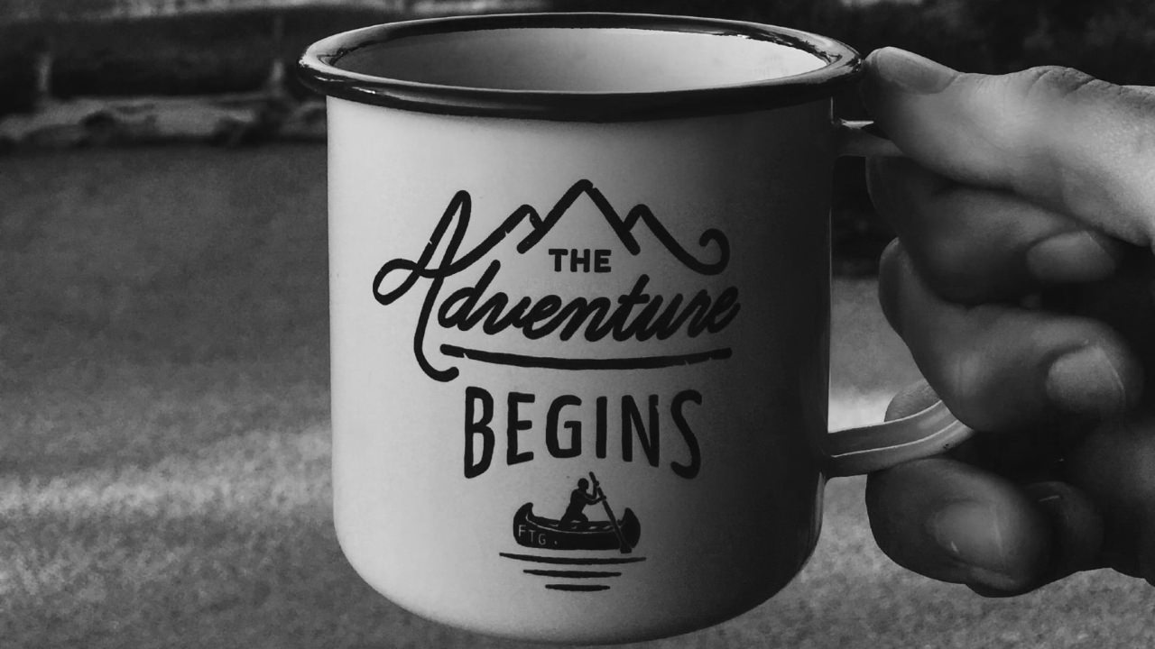 Mug saying ’the adventure begins’