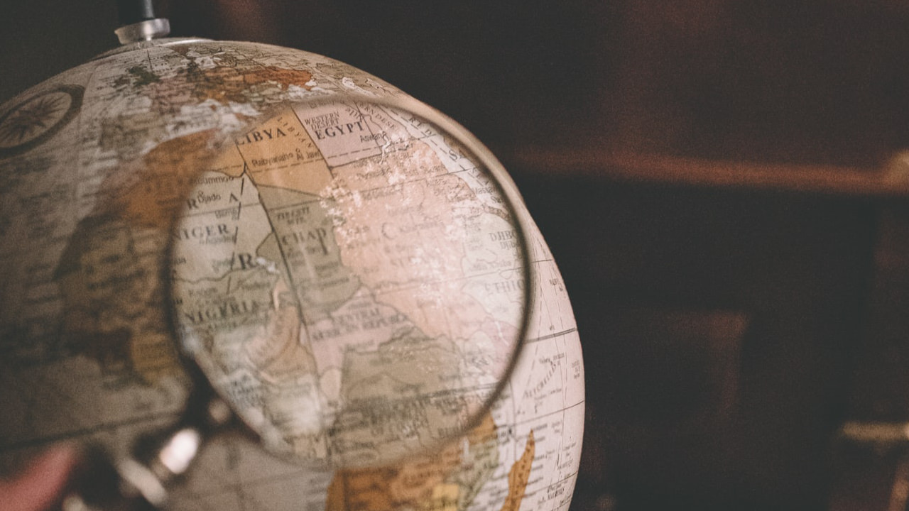 An old style globe with a magnifying glass held over countries in Africa