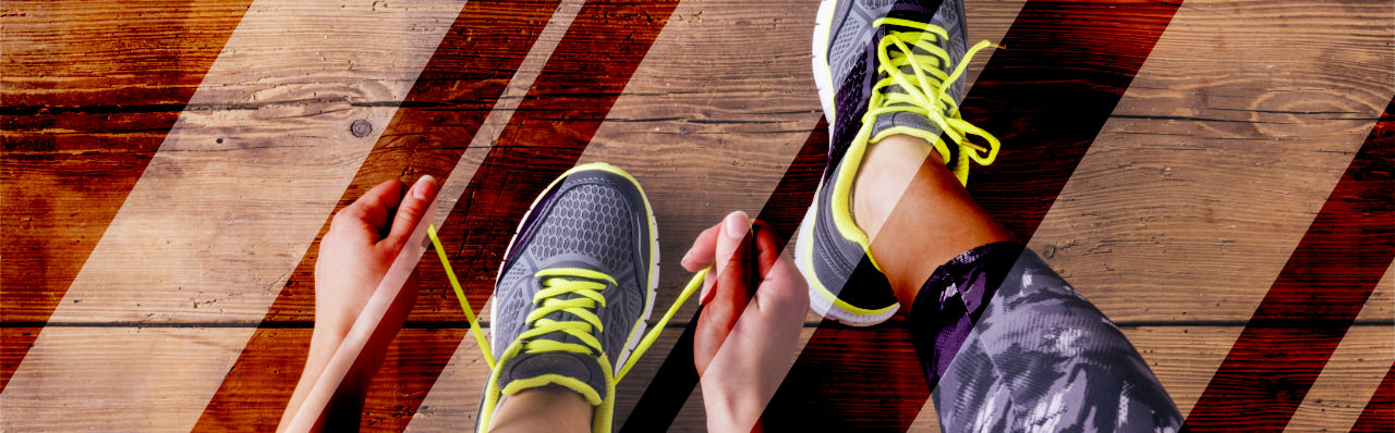 A photo of feet with hands lacing up sports shoes