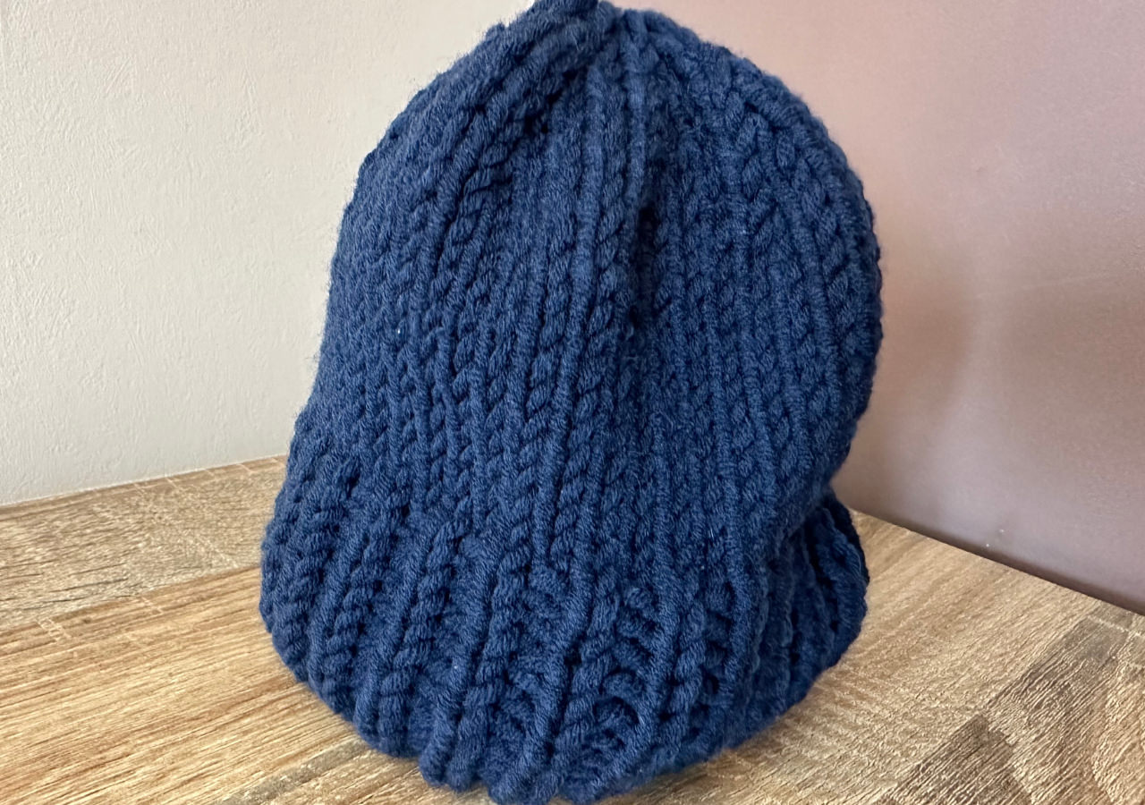 A photograph of a dark blue knitted hat