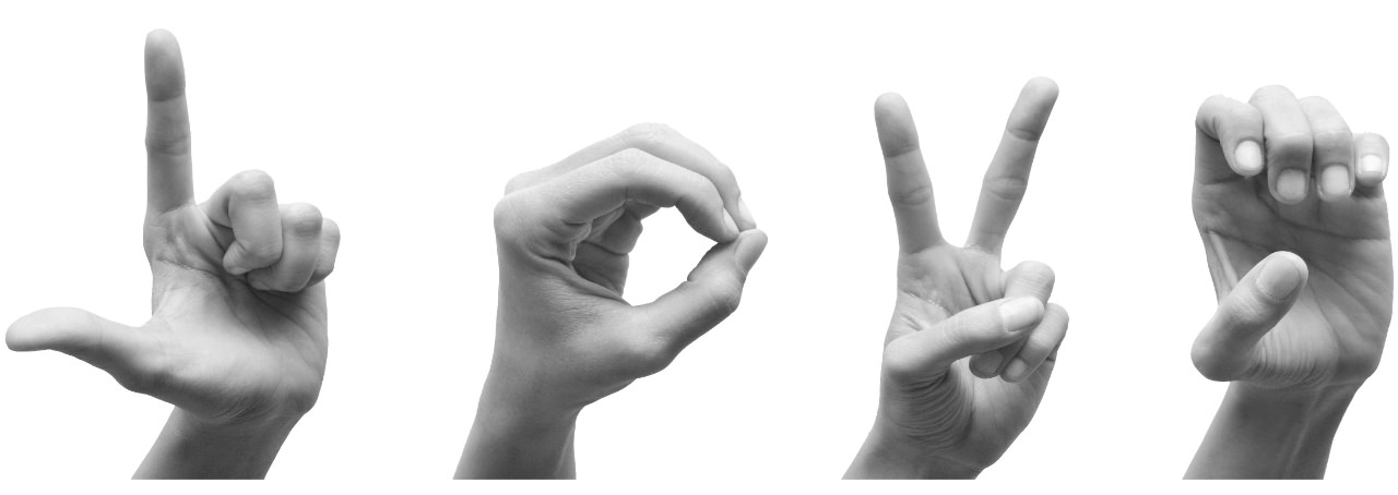 Four hands spell out L-O-V-E in American sign language