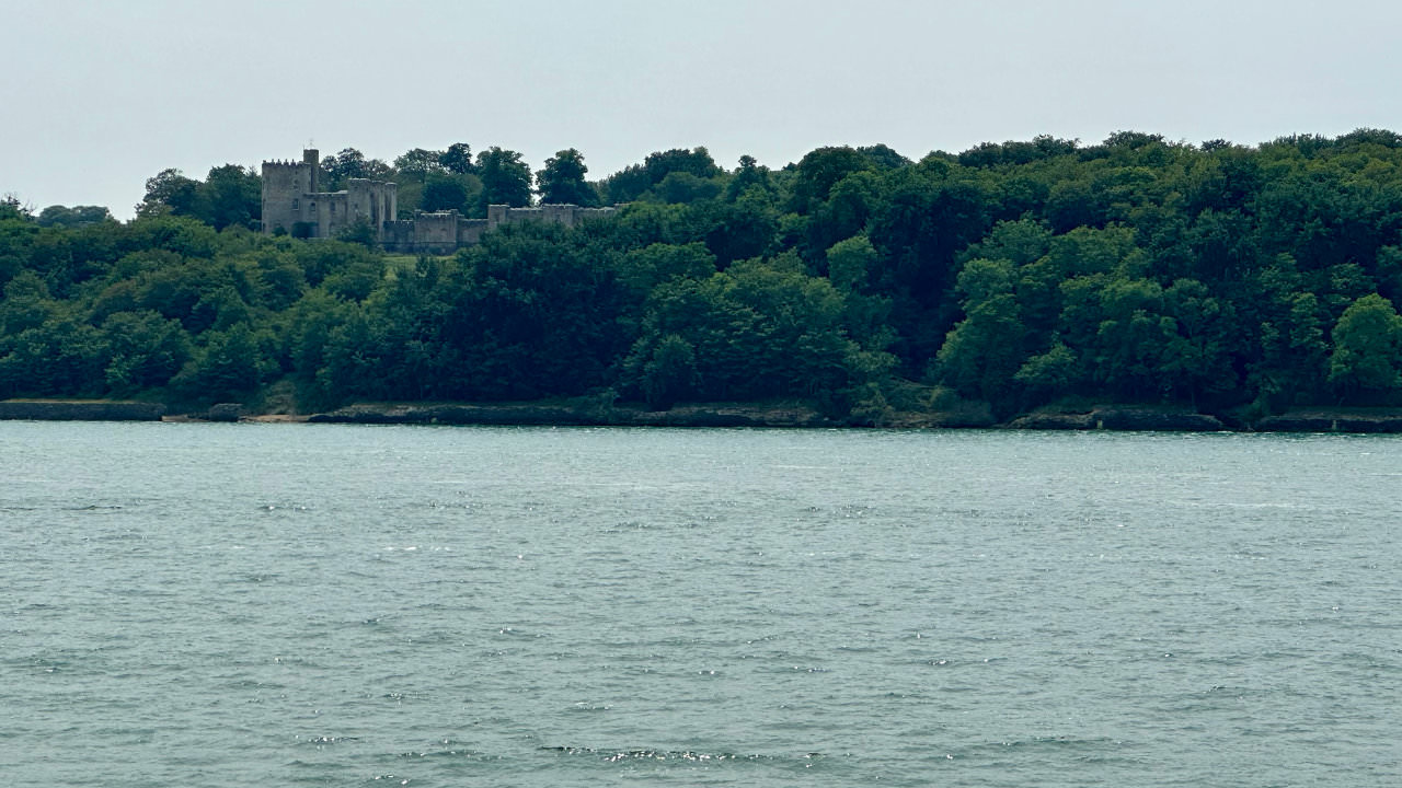 Castle tucked into green forests on the shoreline of the Isle of Wight