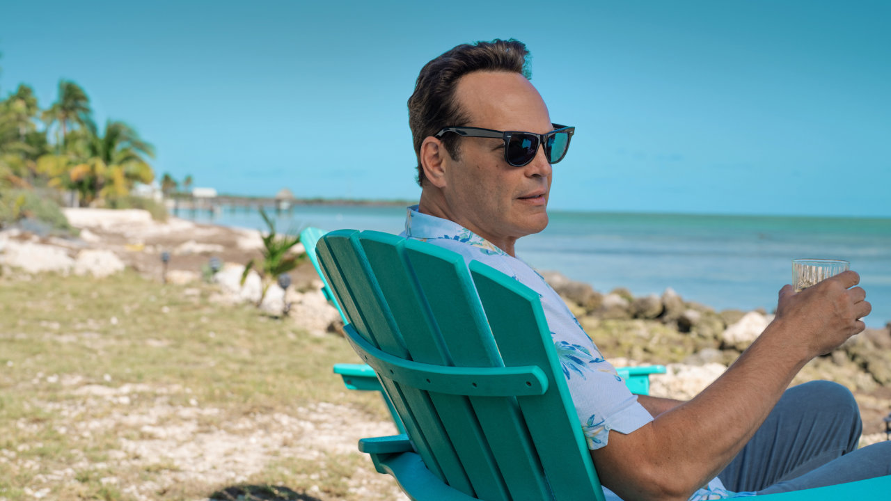 A marketing still from the TV series Bad Monkey, featuring Vince Vaughn looking back at the camera whilst sitting on a deckchair