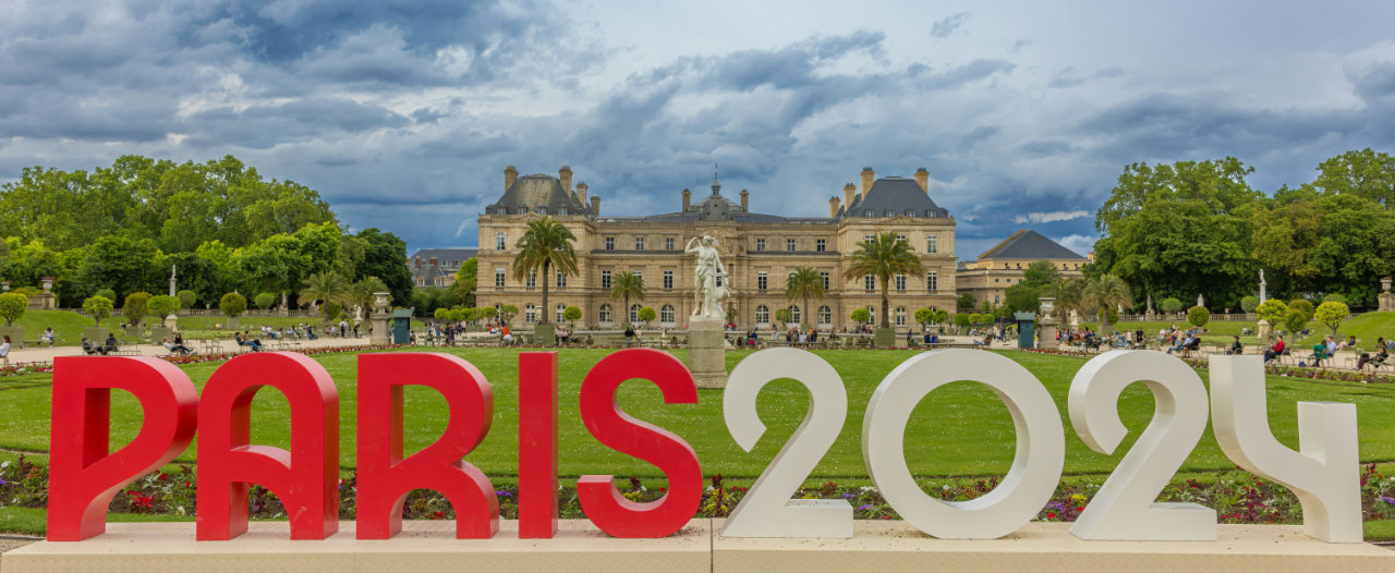 An installation saying &lsquo;Paris 2024&rsquo; in front of a historic palace and gardens