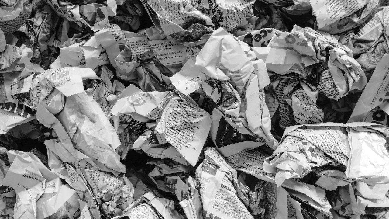 A black and white photograph of scrunched up newspapers ready to be recycled