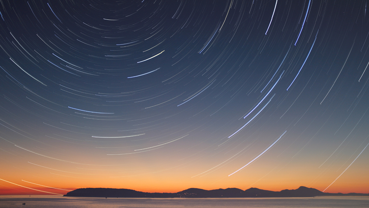 A night sky with timelapse of stars creating blurry circles in the sky