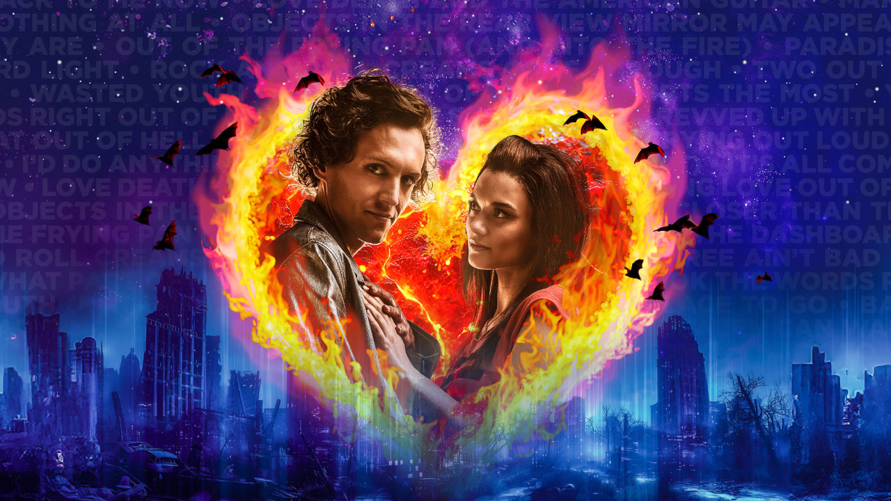 The official marketing still for Bat Out of Hell: The Musical, featuring the two main characters in a heart made of fire against a deep blue city skyline background