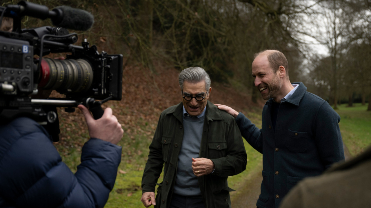 Eugene Levy and Prince William walk and talk during filming of the Apple TV series The Reluctant Traveller