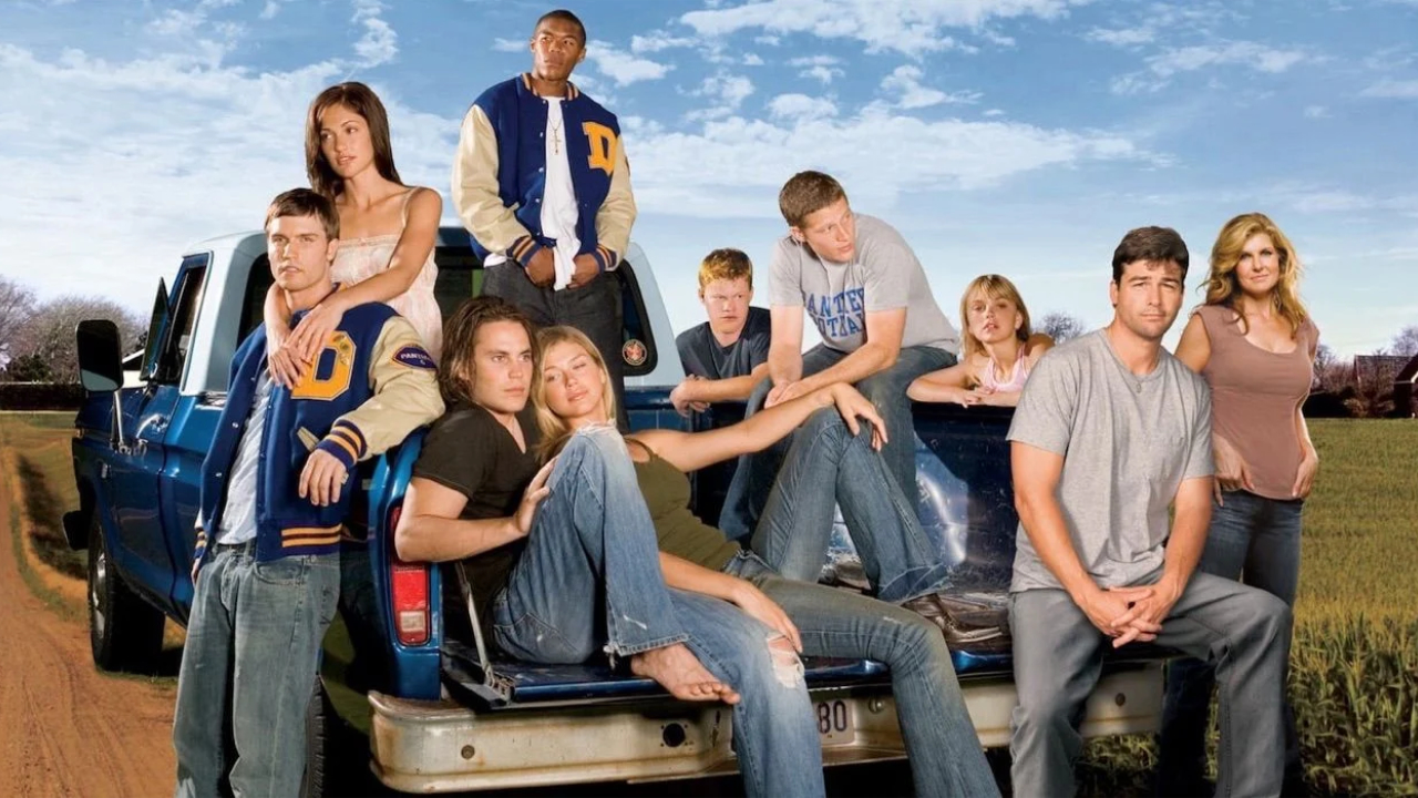 A marketing poster for the TV show Friday Night Lights, featuring all the main characters sitting on and around a truck in rural America