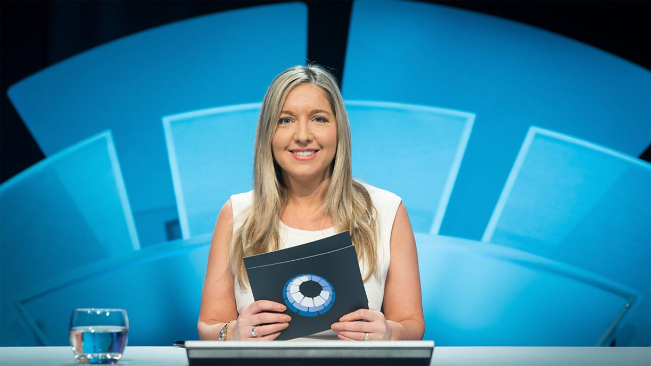 A photo of Only Connect host Victoria Coren Mitchell in her host’s seat, holding quiz cards
