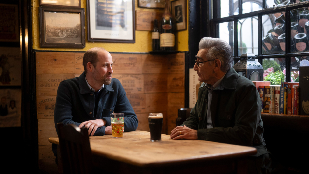 Eugene Levy and Prince William share a drink in a pub during filming of the Apple TV series The Reluctant Traveller