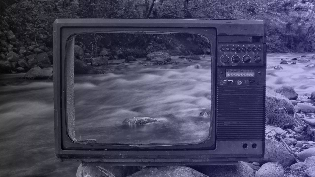 The front of a television screen sitting on the river streaming past as if it is on the screen