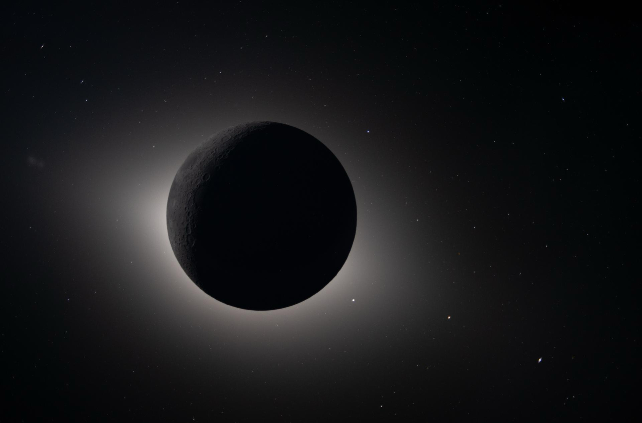 A photo from NASA&rsquo;s Artemis II lunar flyby collection, featuring the full circle of the moon in shadow with a halo of light around it