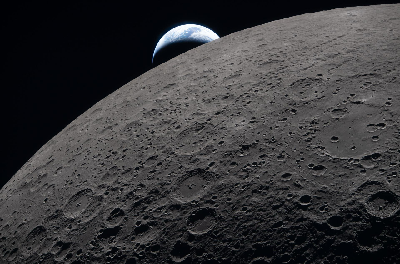 A photo from NASA&rsquo;s Artemis II lunar flyby collection, featuring the grey, cratered moon up close with the much smaller earth peeking just around the curve of the lunar surface